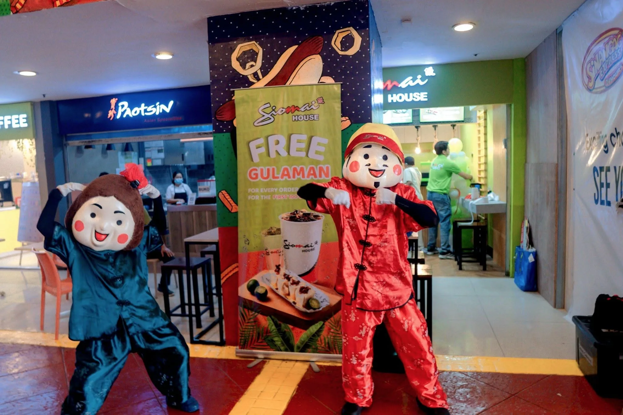 Siomai House mascots greeting customers outside a branch
